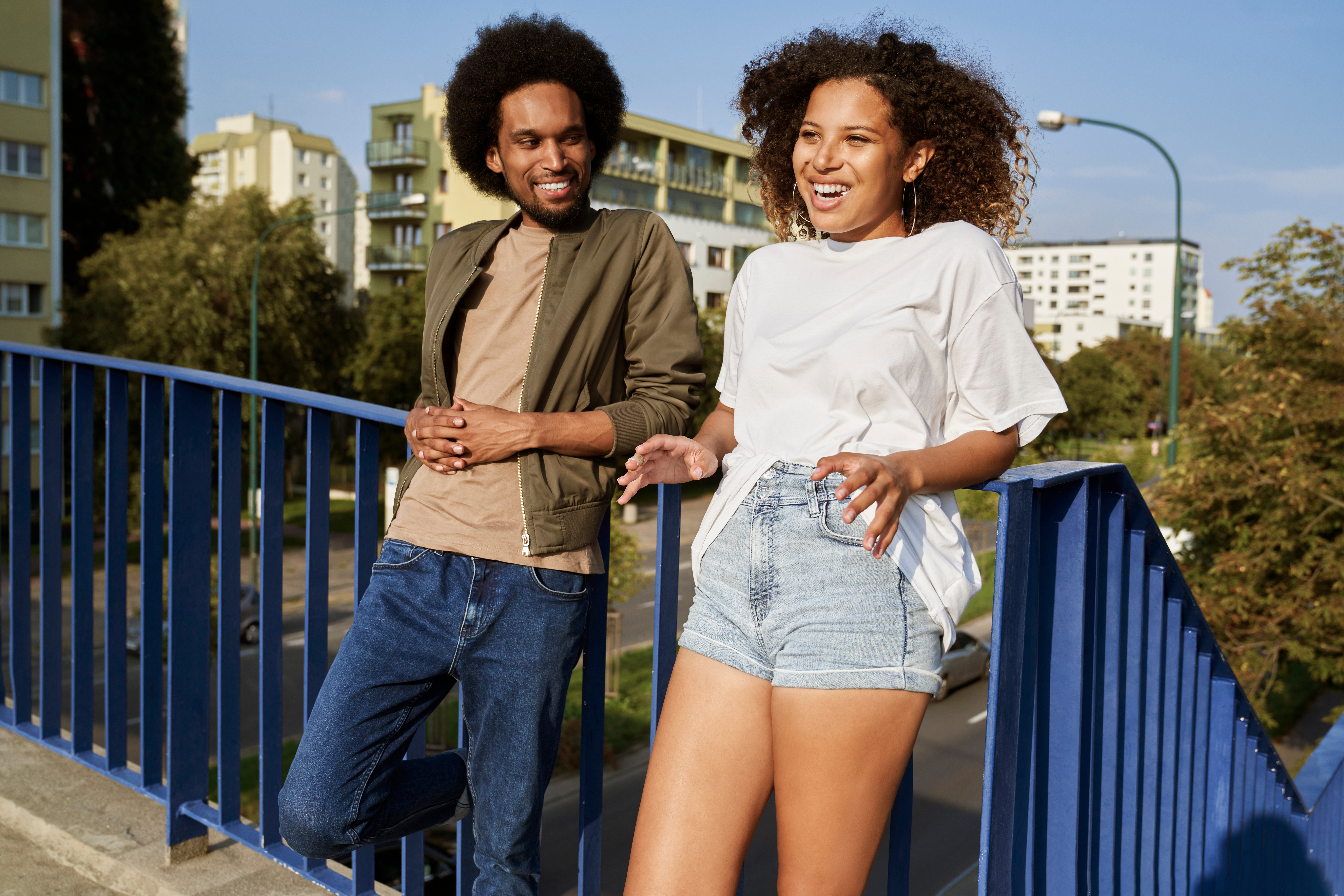 Couple,Standing,Leaning,Against,The,Railing,And,Talking,Together