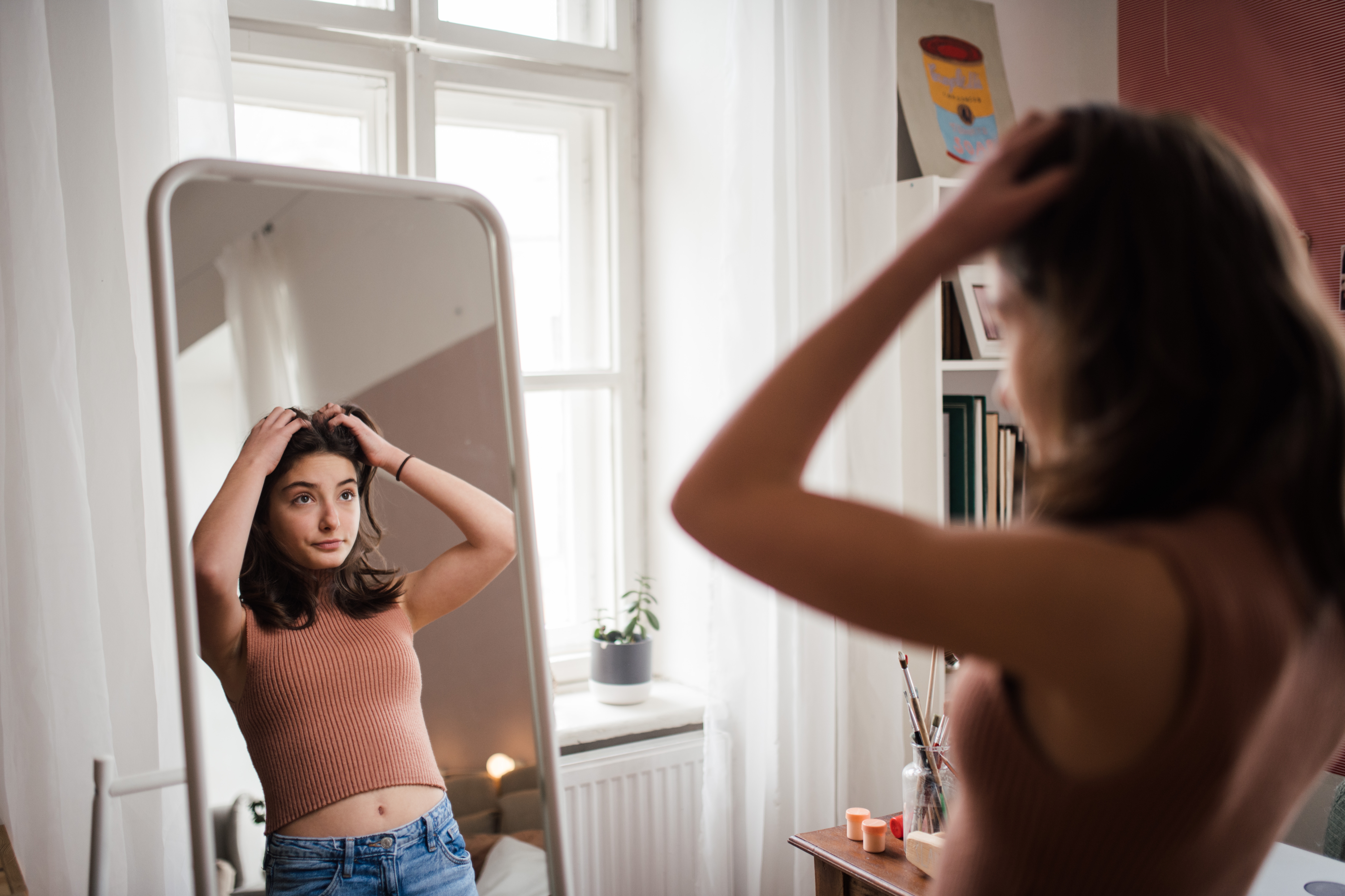 Young,Teenage,Girl,Looking,In,The,Mirror,In,Her,Room.